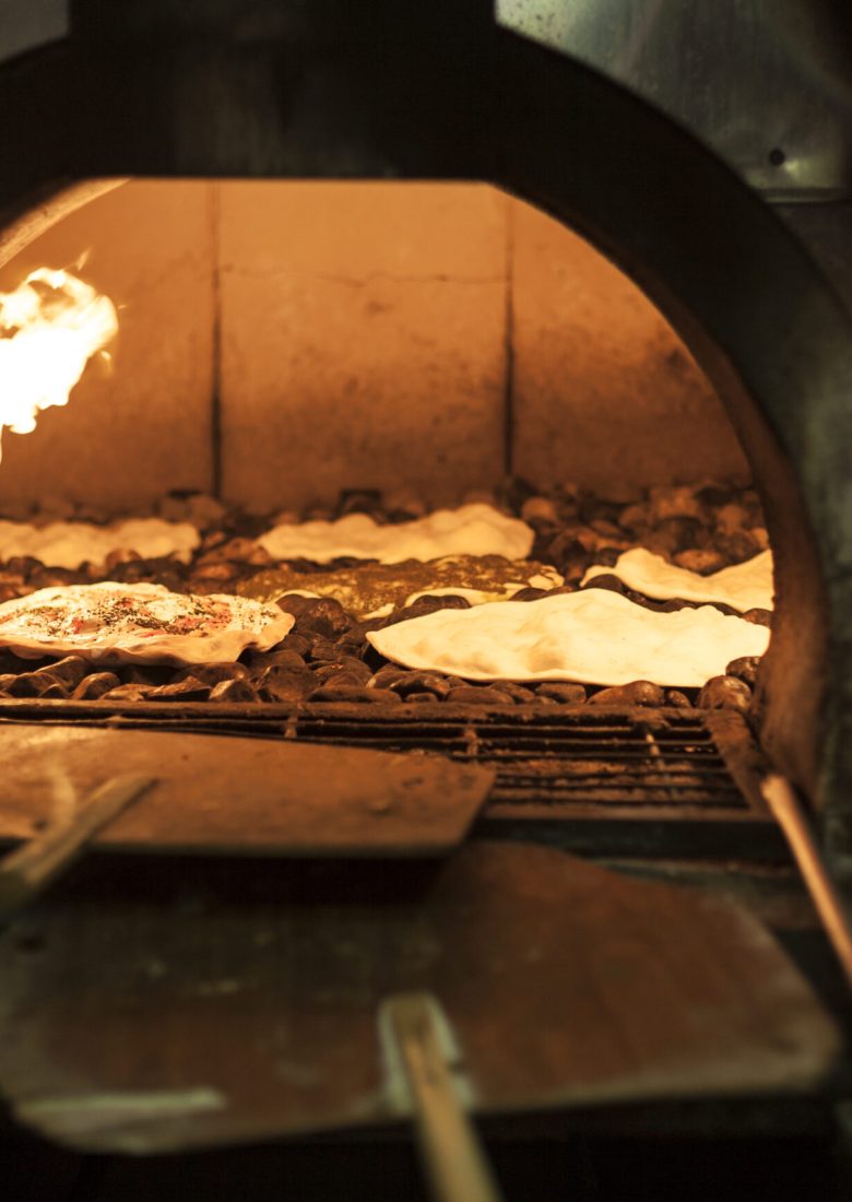Old style middle east stone oven with flat bread with different spices inside