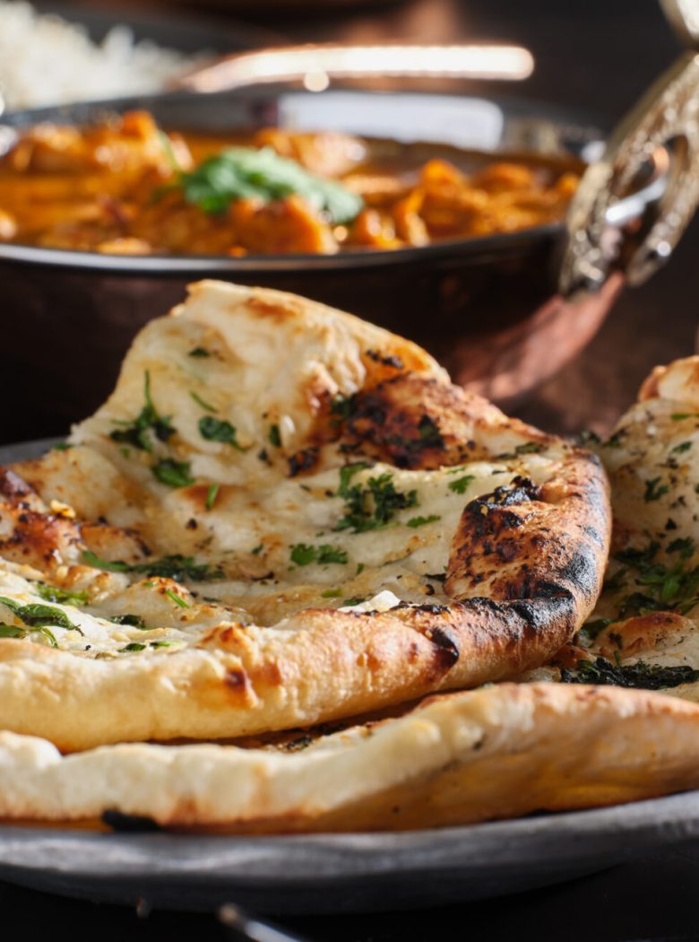 indian naan bread with herbs and garlic seasoning on plate
