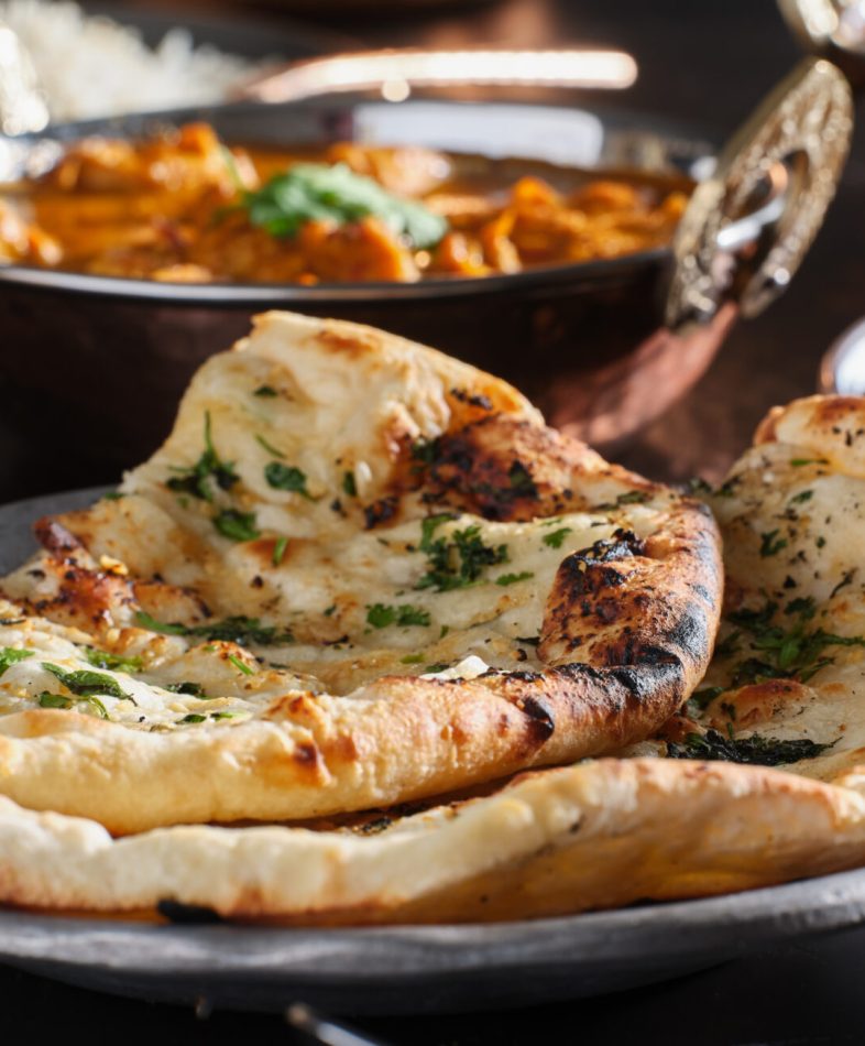 indian naan bread with herbs and garlic seasoning on plate