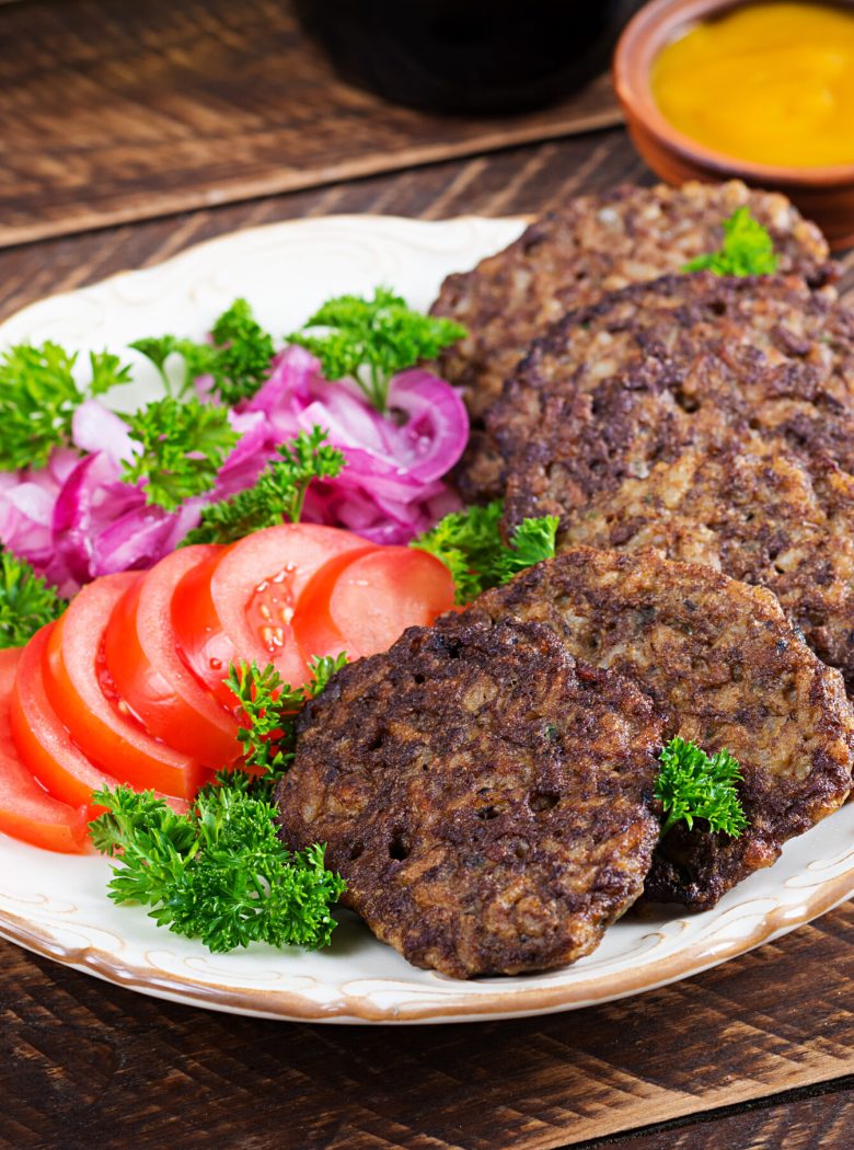 Chicken liver pancakes with vegetables  on wooden background. Fried chicken liver fritters idea. Rustic style.