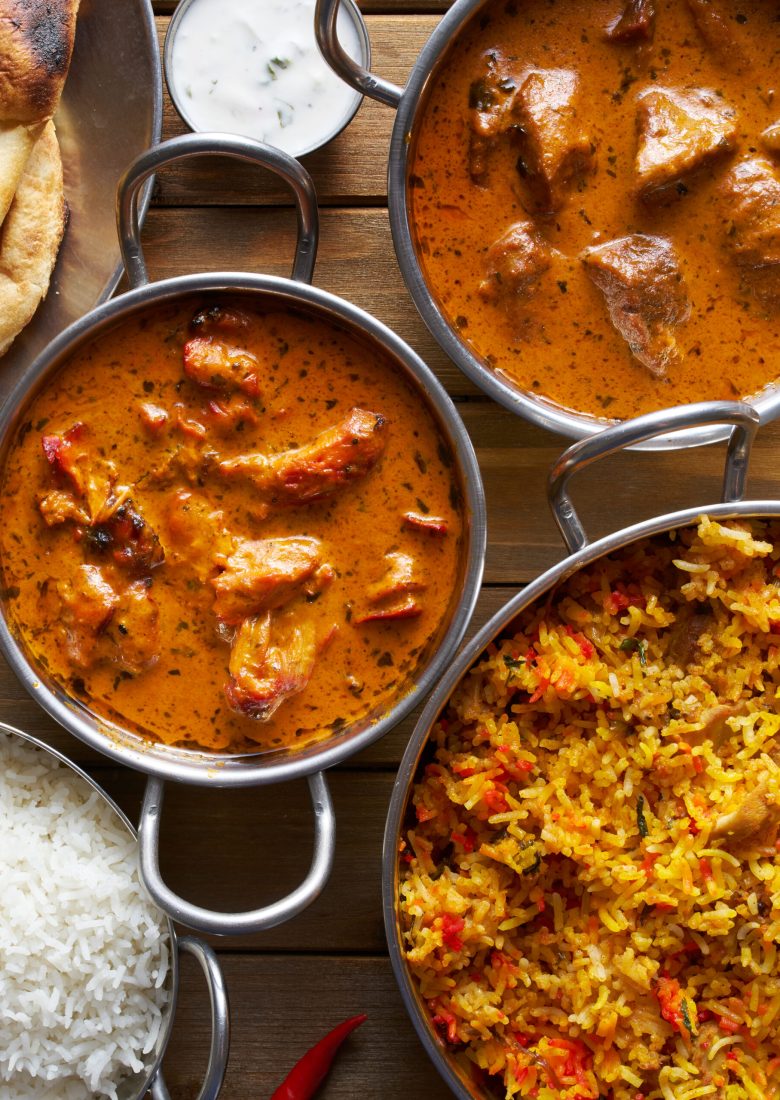 assortment of indian curry and rice dishes shot from overhead composition