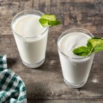 Ayran drink with mint and cucumber in glass on wooden table